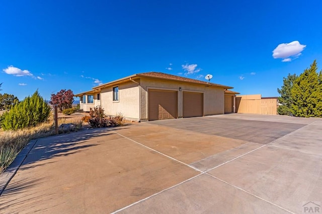 view of front of property with driveway, an attached garage, and stucco siding