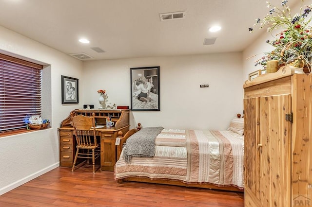 bedroom with visible vents, baseboards, wood finished floors, and recessed lighting