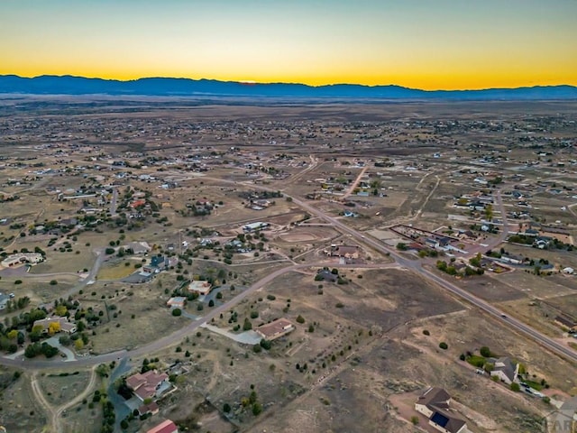 aerial view at dusk featuring a mountain view