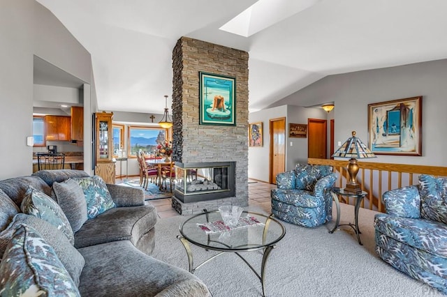 living room featuring light carpet, vaulted ceiling with skylight, and a fireplace