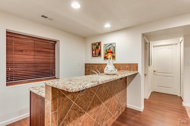 bar featuring baseboards, visible vents, wood finished floors, and recessed lighting