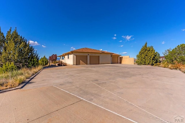 view of front of house with driveway, a garage, and stucco siding