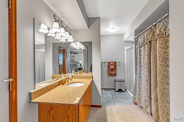 bathroom featuring a stall shower, tile patterned flooring, baseboards, and vanity