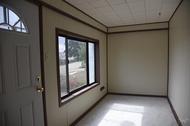 unfurnished room featuring ornamental molding and baseboards