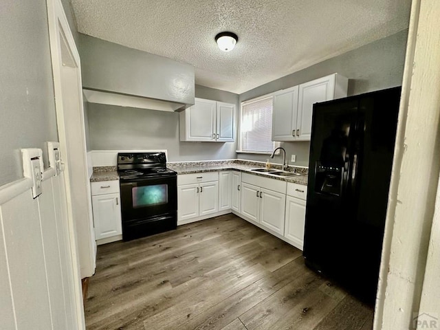 410 W 25th St, Pueblo, CO 81003 - kitchen featuring black appliances, a sink, white cabinetry, dark wood-style floors, and a textured ceiling
