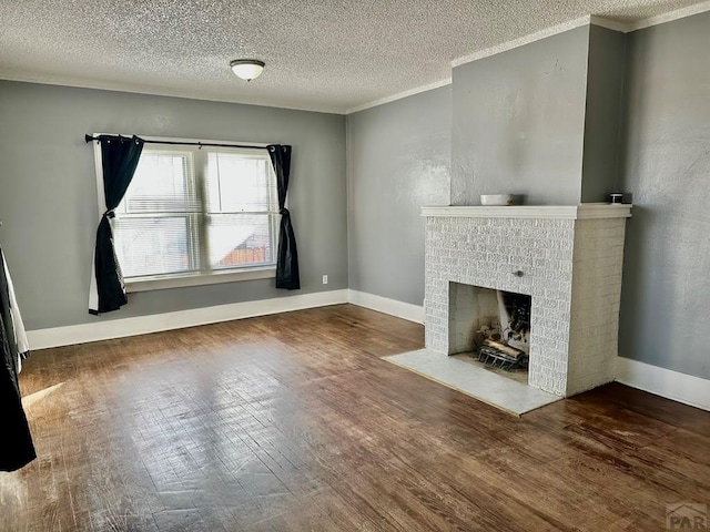 410 W 25th St, Pueblo, CO 81003 - unfurnished living room with wood finished floors, a textured ceiling, a brick fireplace, crown molding, and baseboards