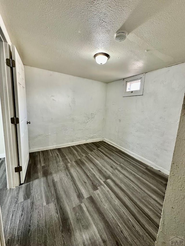 410 W 25th St, Pueblo, CO 81003 - basement with dark wood-style flooring, baseboards, and a textured ceiling
