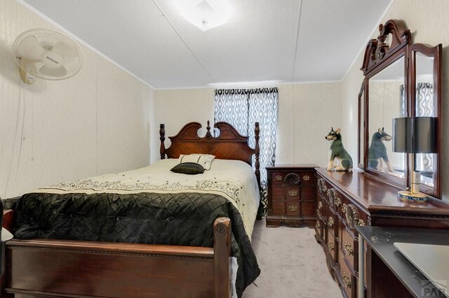 bedroom with light colored carpet and crown molding