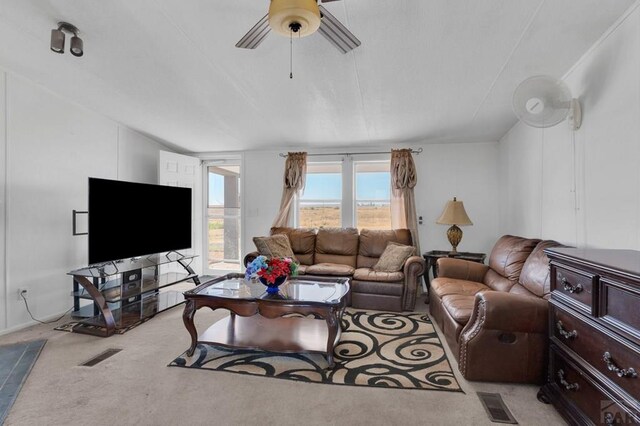 living area featuring light carpet, visible vents, and a ceiling fan