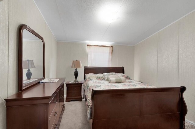 bedroom featuring light carpet, crown molding, and a decorative wall