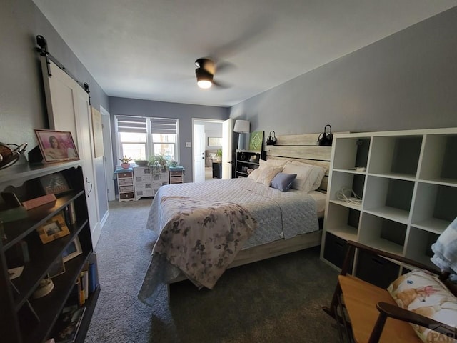 2602 3rd Ave, Pueblo, CO 81003 - bedroom featuring a barn door, dark carpet, and ceiling fan