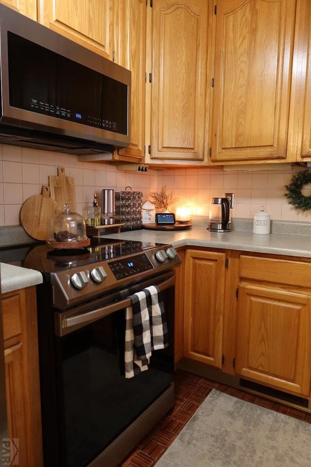 kitchen with stainless steel appliances, tasteful backsplash, and light countertops