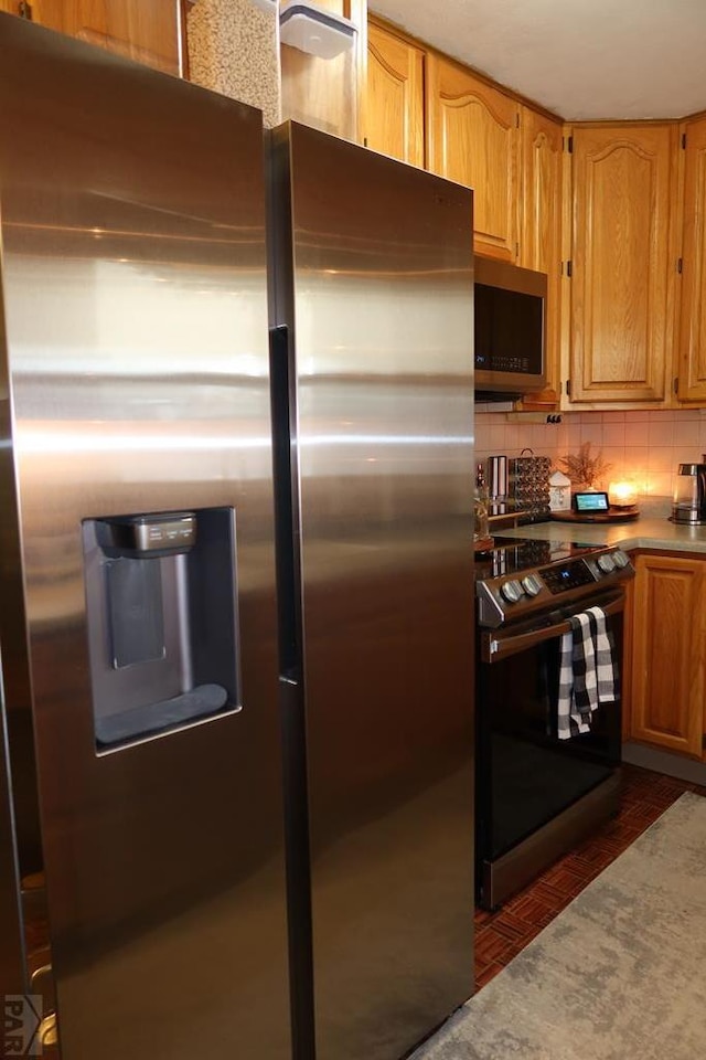 kitchen featuring stainless steel appliances and tasteful backsplash