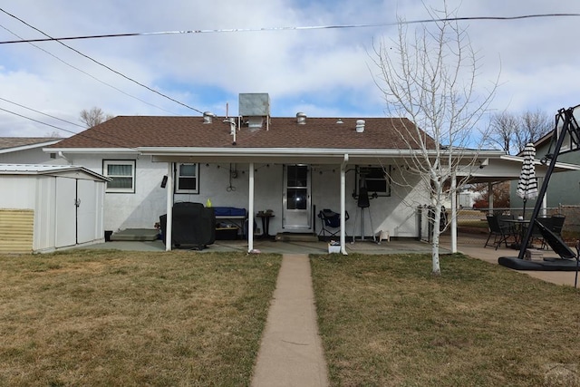 back of property with an outbuilding, a patio, a storage shed, and a lawn