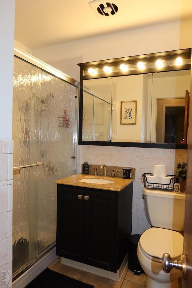 full bath featuring a stall shower, vanity, and tile walls