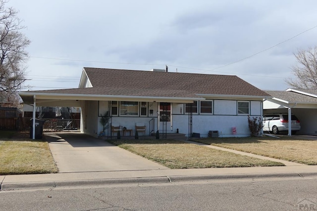 ranch-style home featuring a carport, a front lawn, a shingled roof, and fence