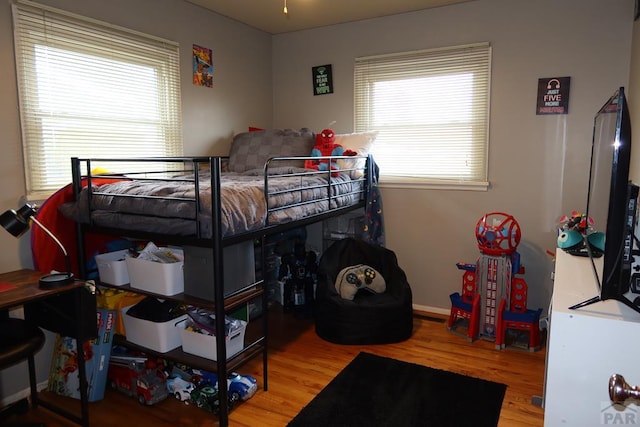 bedroom featuring baseboards and wood finished floors