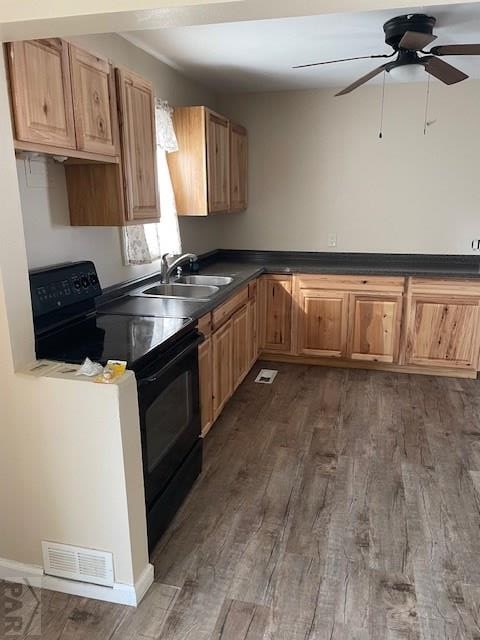 kitchen featuring dark wood-style floors, dark countertops, visible vents, black range with electric stovetop, and a sink