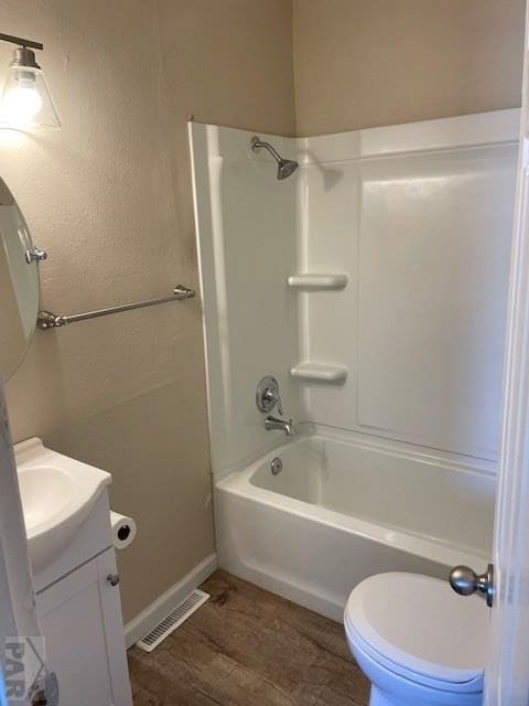 bathroom featuring bathtub / shower combination, toilet, wood finished floors, vanity, and visible vents