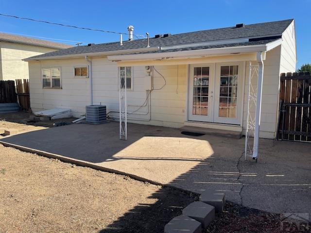 back of house featuring a patio area, fence, central AC, and french doors