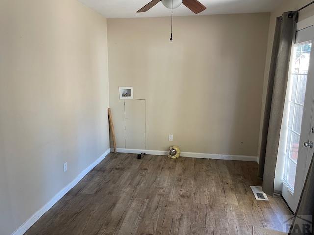 laundry room with laundry area, washer hookup, wood finished floors, visible vents, and baseboards