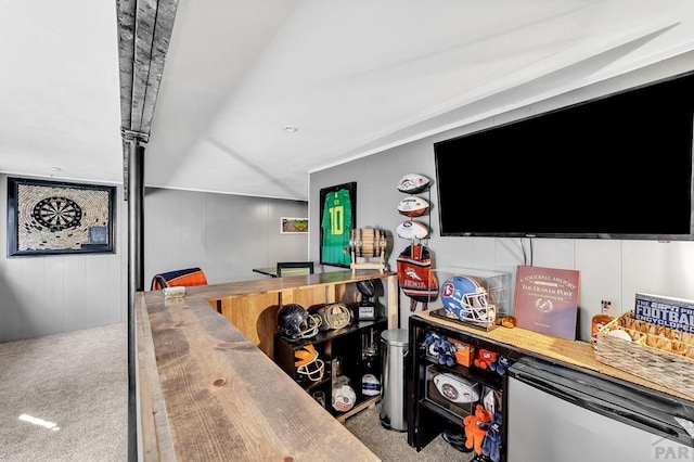 bar with fridge, a dry bar, and carpet flooring