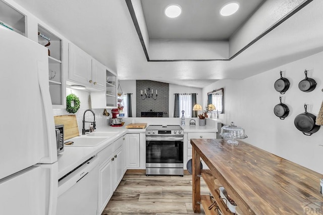 kitchen featuring a sink, a tray ceiling, white appliances, white cabinetry, and open shelves