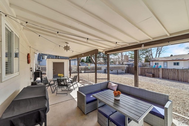 view of patio featuring an outdoor living space, a fenced backyard, an outdoor structure, and outdoor dining space