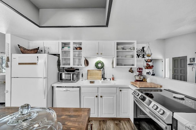 kitchen with open shelves, white cabinetry, appliances with stainless steel finishes, and a sink