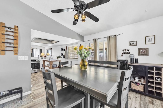 dining space with ceiling fan, light wood-style floors, and lofted ceiling