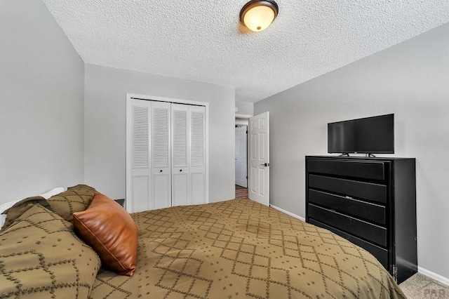 carpeted bedroom with baseboards, a closet, and a textured ceiling