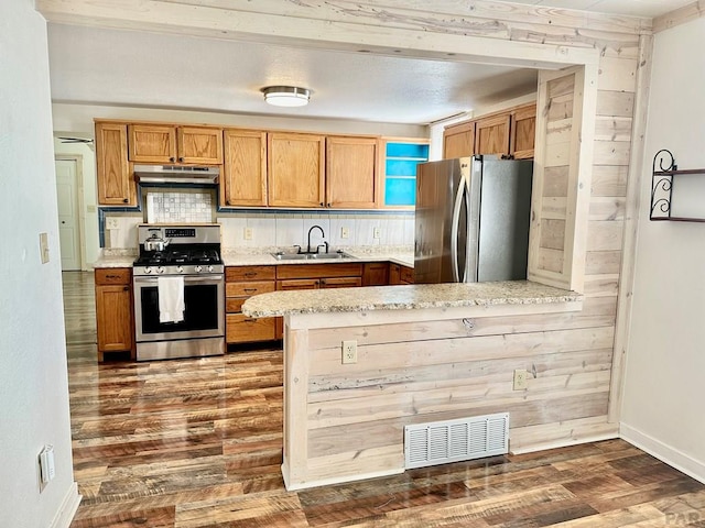 kitchen with visible vents, dark wood-style floors, appliances with stainless steel finishes, under cabinet range hood, and a sink