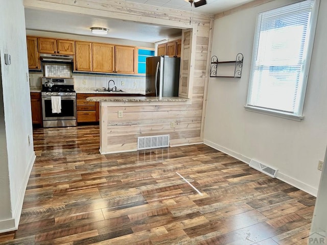 kitchen with stainless steel appliances, light countertops, visible vents, dark wood-type flooring, and a sink