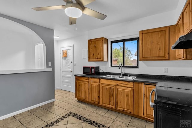 2720 E 8th St, Pueblo, CO 81001 - kitchen with electric range oven, black microwave, light tile patterned floors, brown cabinetry, and dark countertops