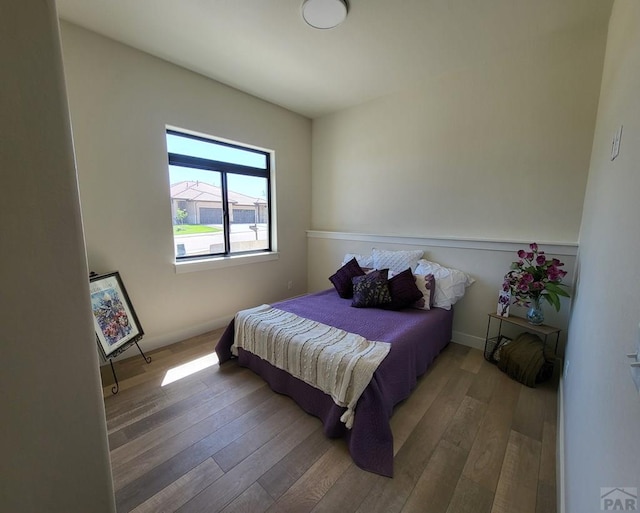 bedroom with baseboards and wood finished floors