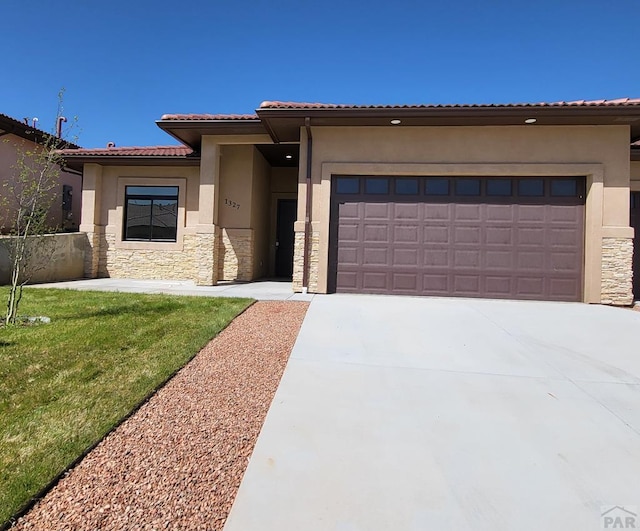 view of front of property with a garage, stone siding, driveway, and stucco siding