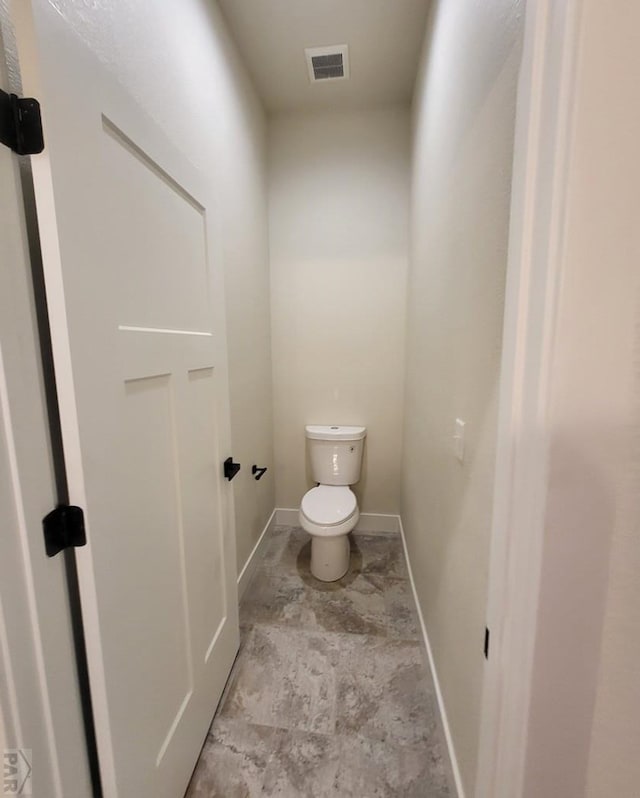 bathroom featuring baseboards, visible vents, and toilet