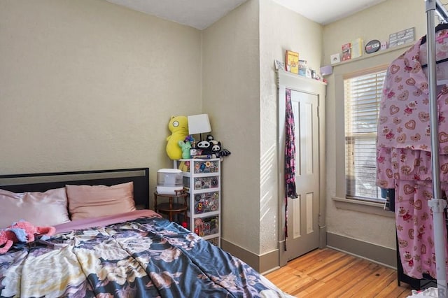 bedroom with light wood-type flooring and baseboards