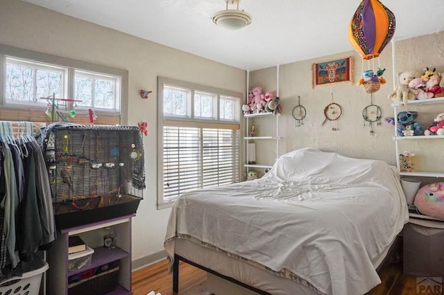 bedroom with baseboards and wood finished floors