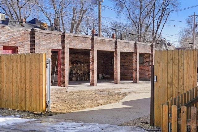 view of property exterior featuring brick siding and fence