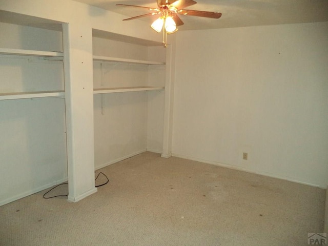 unfurnished bedroom featuring light colored carpet, ceiling fan, and baseboards