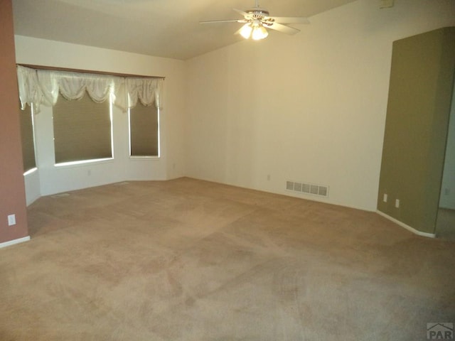 carpeted spare room with ceiling fan and visible vents