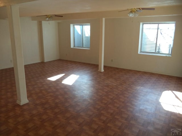 below grade area featuring a ceiling fan and plenty of natural light