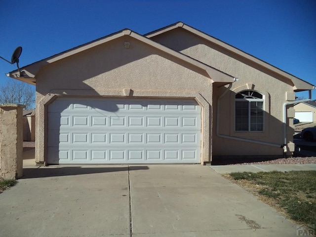 view of front of property with driveway, a garage, and stucco siding