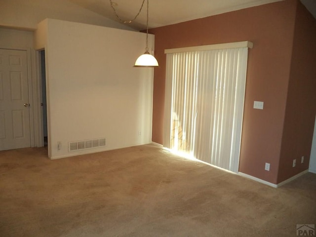 unfurnished room with carpet floors, visible vents, and vaulted ceiling