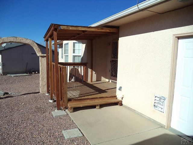 view of exterior entry featuring a patio area and stucco siding