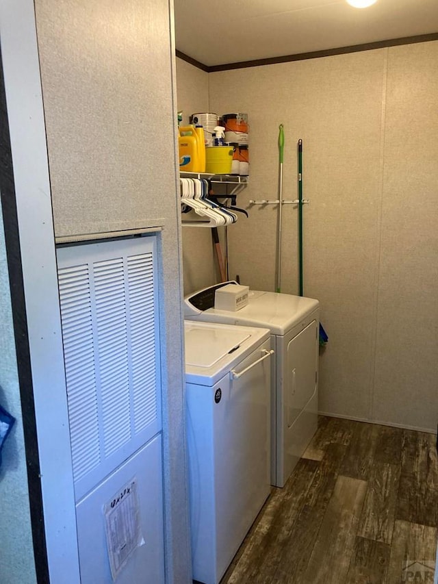 laundry area featuring laundry area, ornamental molding, dark wood-style flooring, and washing machine and dryer