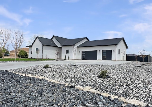 view of front facade with an attached garage, driveway, and stucco siding