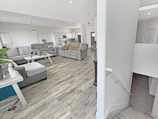 living area with baseboards, light wood-style floors, and recessed lighting