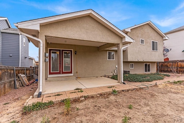 back of house with a patio, a fenced backyard, and stucco siding